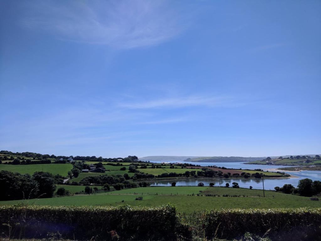 a view of a river from a hill with a field at Seafield Farmhouse in Kilbrittain