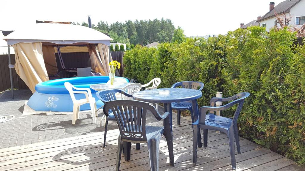 un patio con tavolo, sedie e vasca idromassaggio di Babite Guest House a Babīte