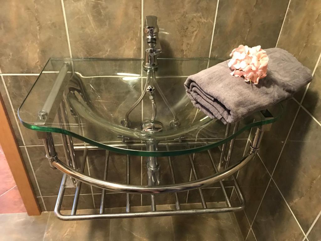 szklaną wannę z ręcznikiem na metalowym wieszaku w obiekcie Budyně Apartment w mieście Budyně nad Ohří