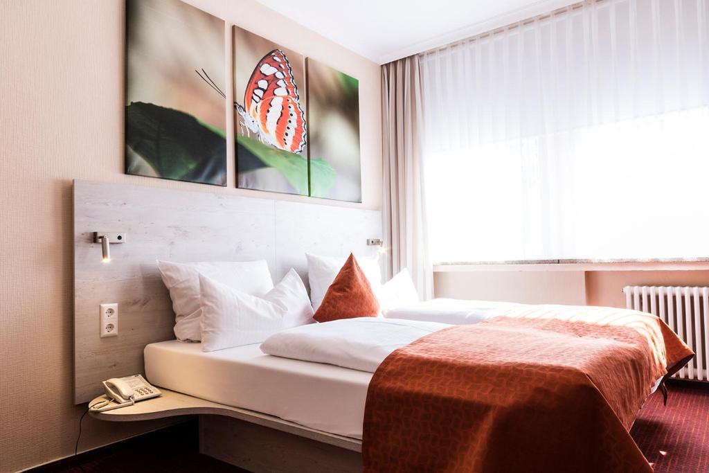 a hotel room with a bed with a large window at Hotel Elisabetha Garni in Hannover