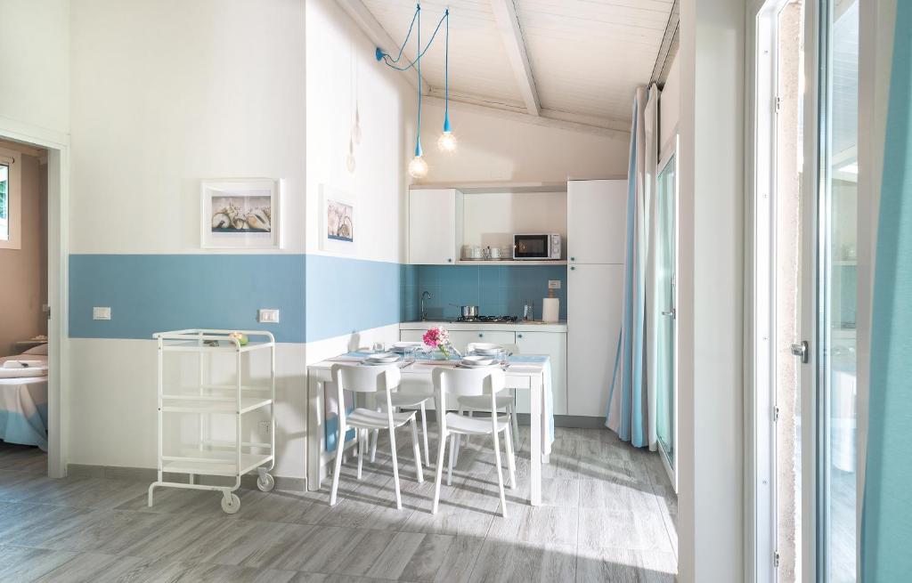 a kitchen with a table and chairs in a room at Villaggio San Francesco in Duna Verde