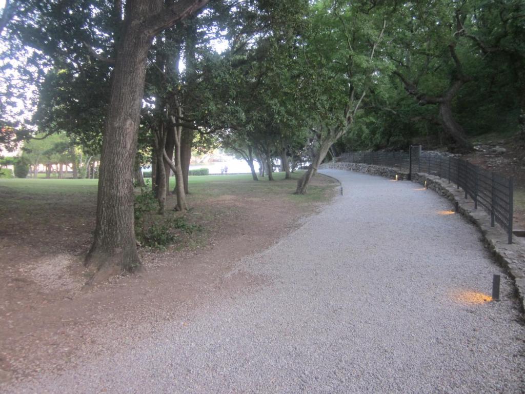 a path in a park with trees and a fence at Apartments Danilo Kažanegra in Sveti Stefan