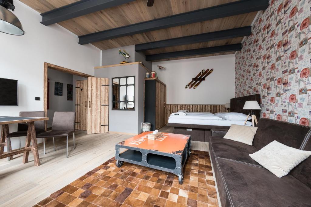 ein Wohnzimmer mit einem Sofa und einem Bett in der Unterkunft Hotel Plzeň in Pilsen