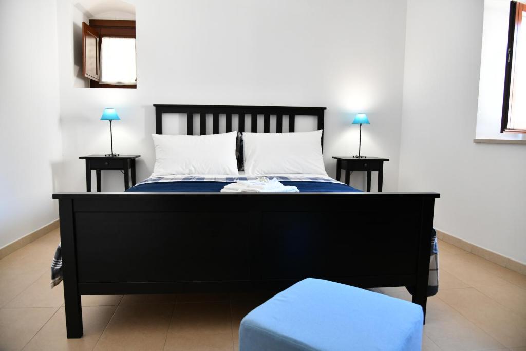 a bedroom with a black bed and two night stands at Casa Vacanze Il RossAntico in Modica