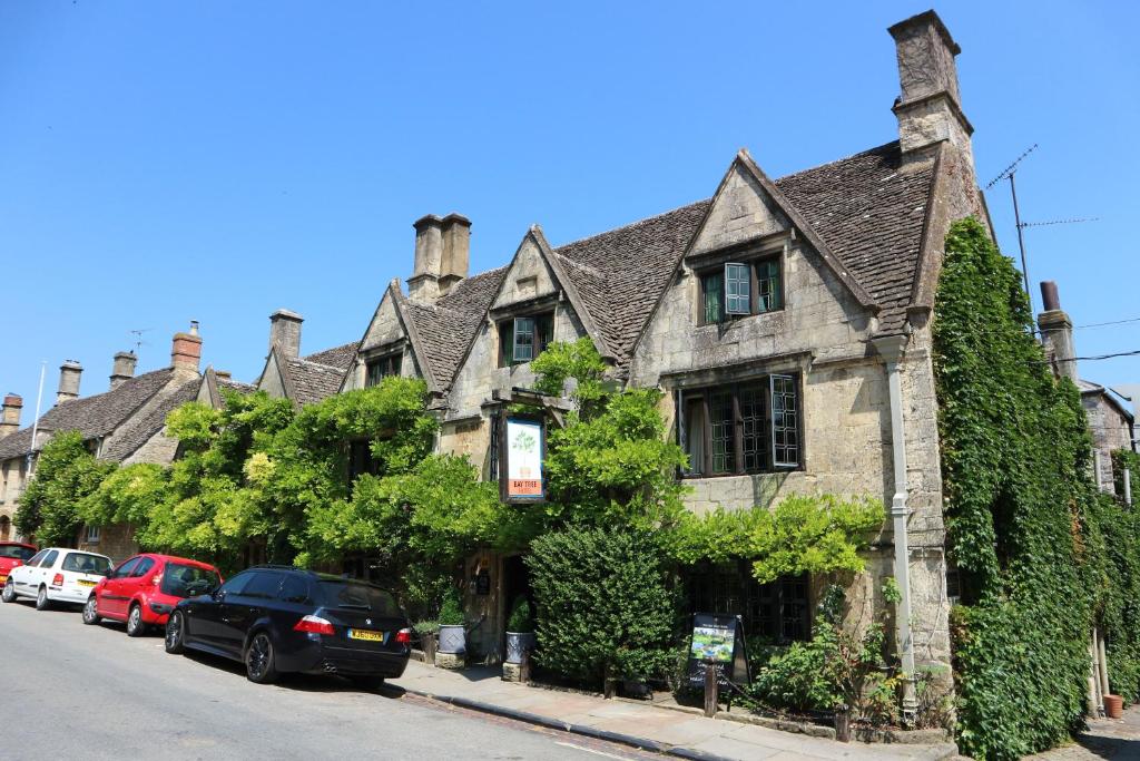 a car parked in front of a house on a street at The Bay Tree Hotel in Burford