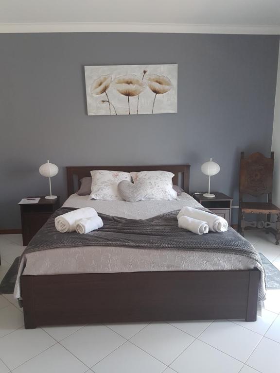 a bedroom with a large bed with two white towels at Dipti's in Ferragudo