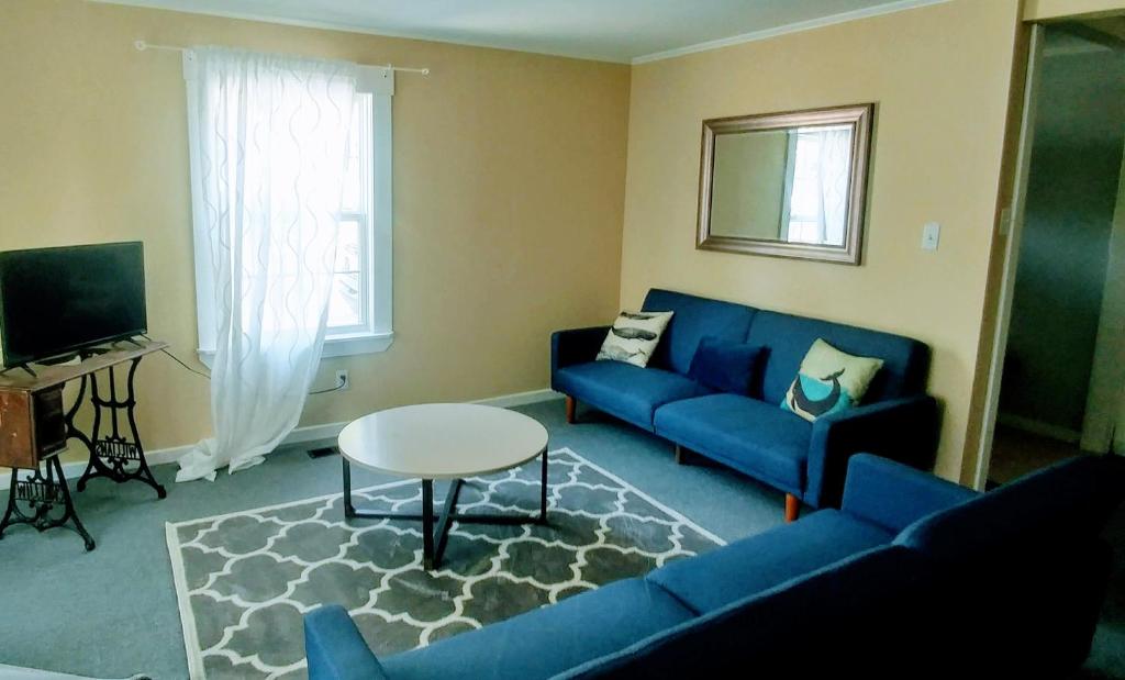 uma sala de estar com um sofá azul e uma mesa em Steps to the Waterfront em Shelburne