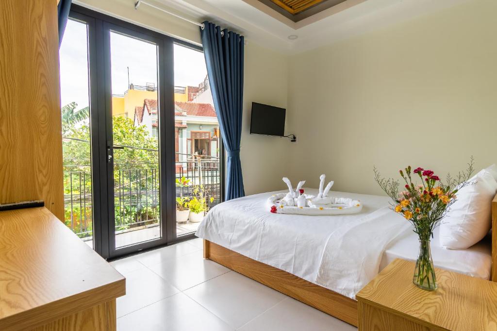 a bedroom with a bed and a large window at D Central Hoi An Homestay in Hoi An