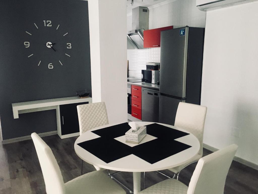 トレビエハにあるApartment in Torrevieja Centreのキッチン(テーブル、椅子、壁掛け時計付)