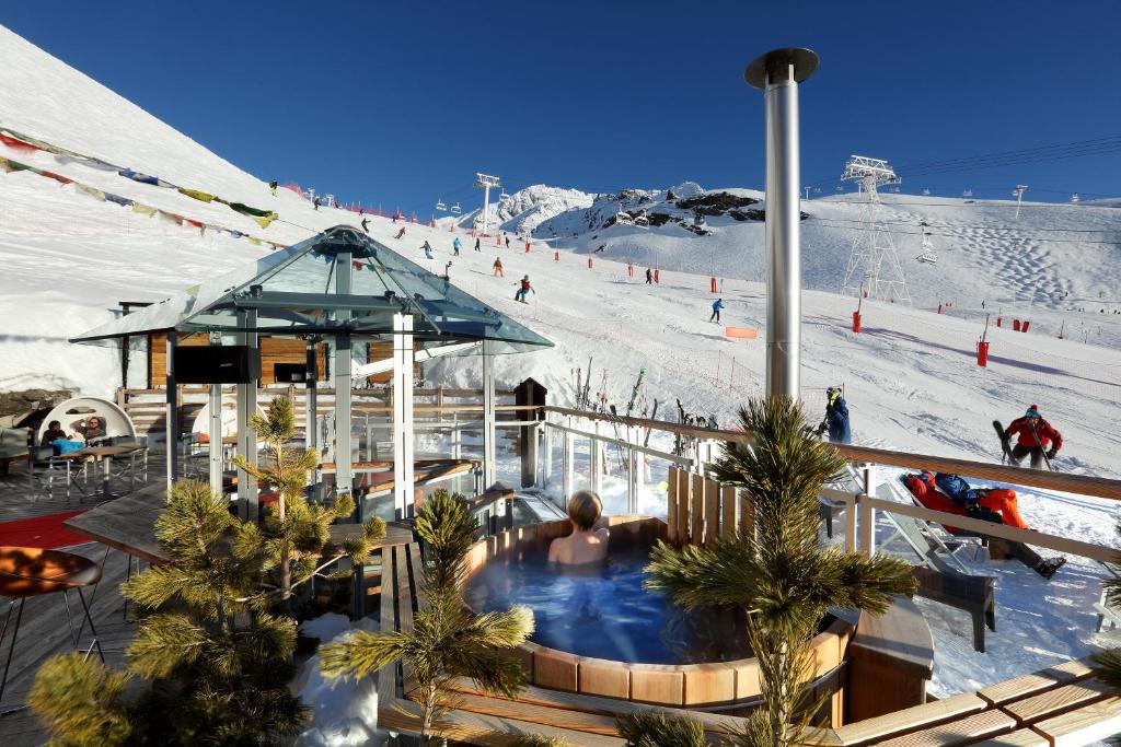 a ski resort with a hot tub and a ski slope at Hotel Pashmina Le Refuge in Val Thorens