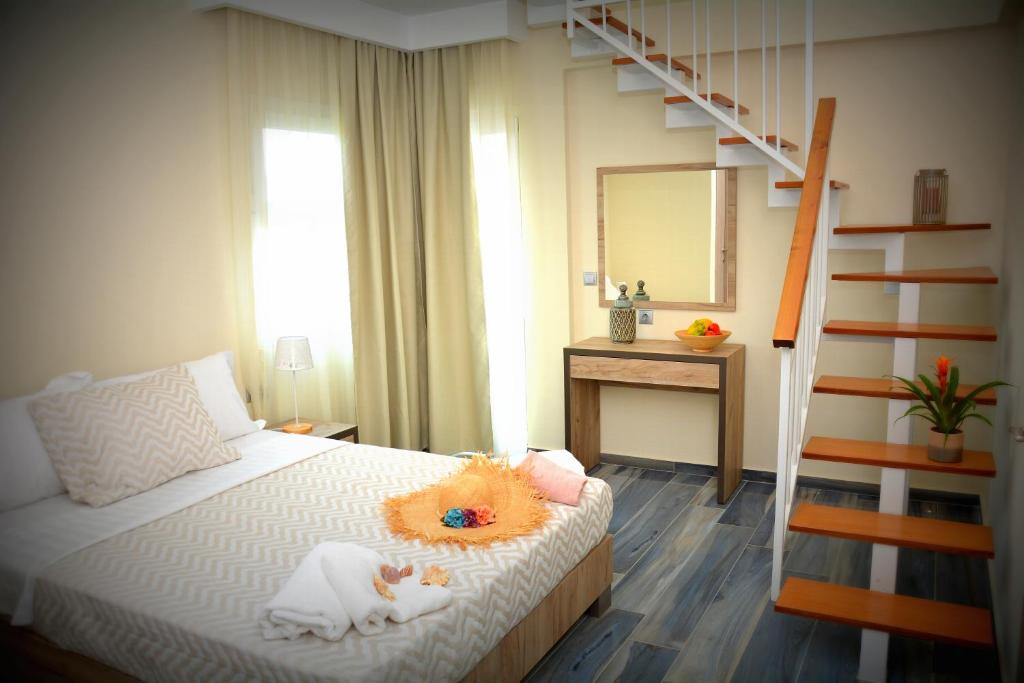 1 dormitorio con 1 cama con escalera y espejo en Vasilicos Sea Stay, en Paralia Katerinis