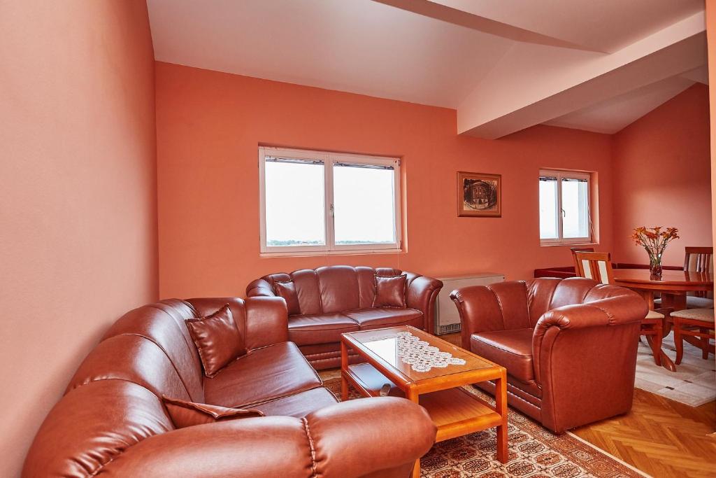 a living room with brown leather furniture and a table at Apartman Jovana Sokobanja in Soko Banja