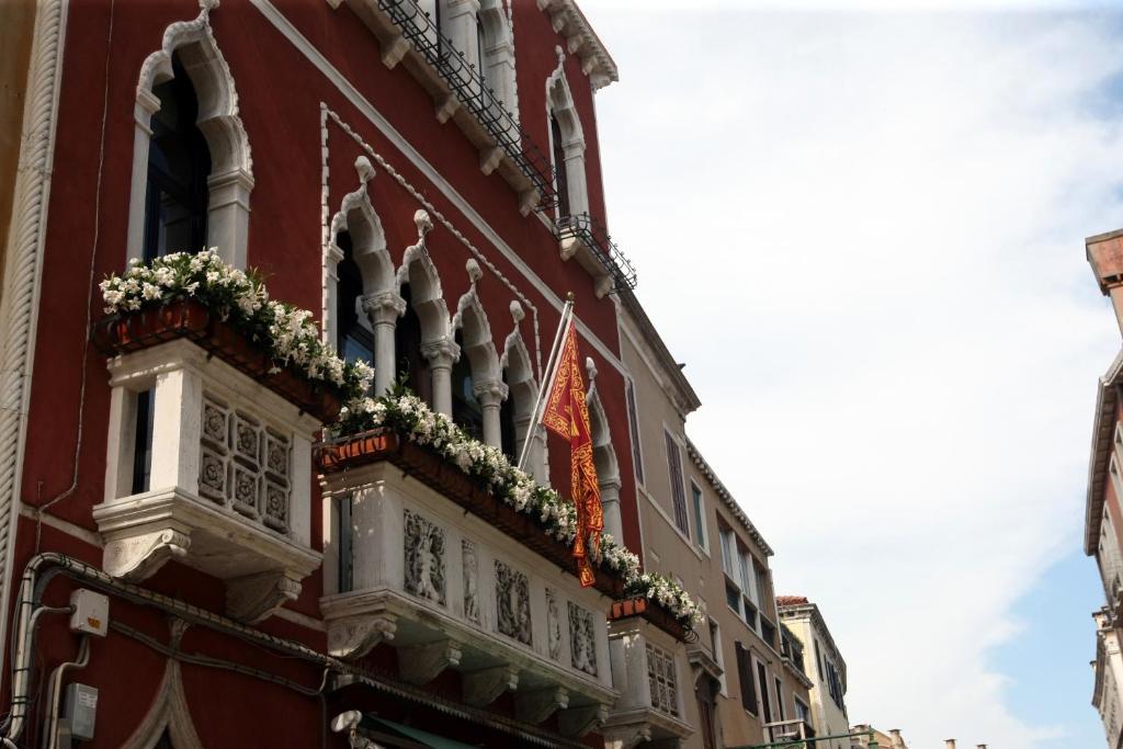 um edifício vermelho com uma varanda com flores em Art Dreams B&B em Veneza