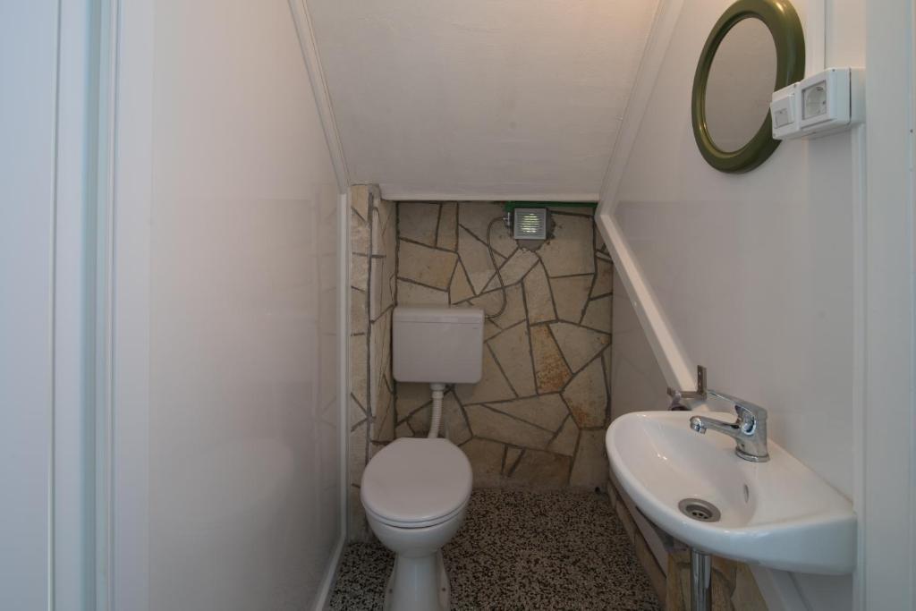 a small bathroom with a toilet and a sink at Apartments Palme in Malinska