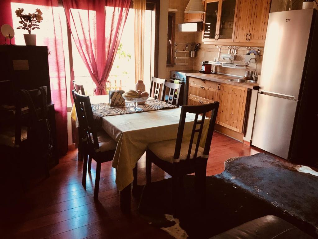 Room 16 في لوس كريستيانوس: مطبخ مع طاولة مع كراسي وثلاجة