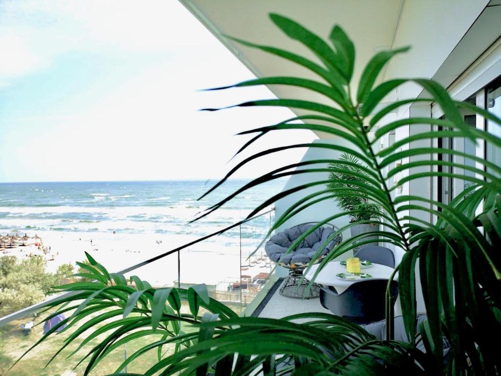a balcony with a table and a view of the beach at White Tower Mamaia - Private Apartment in Mamaia