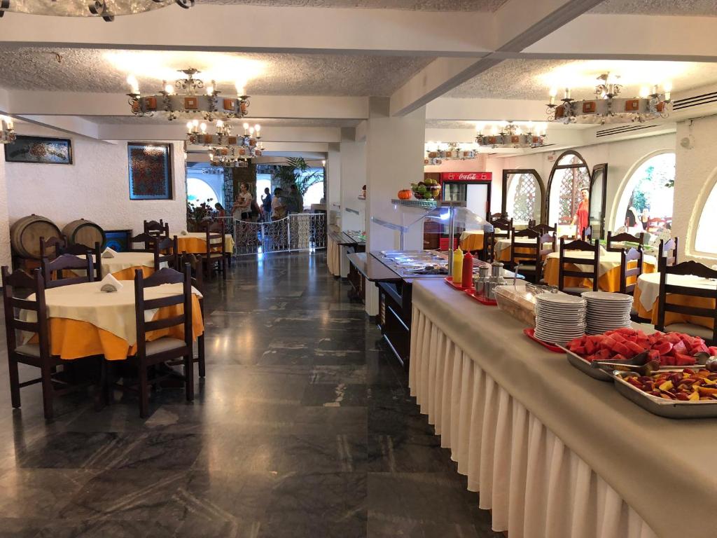 a restaurant with a counter with food on it at Karteros Hotel in Karteros