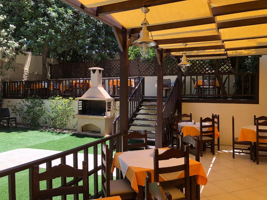 an outdoor patio with tables and a stove at Karteros Hotel in Karteros