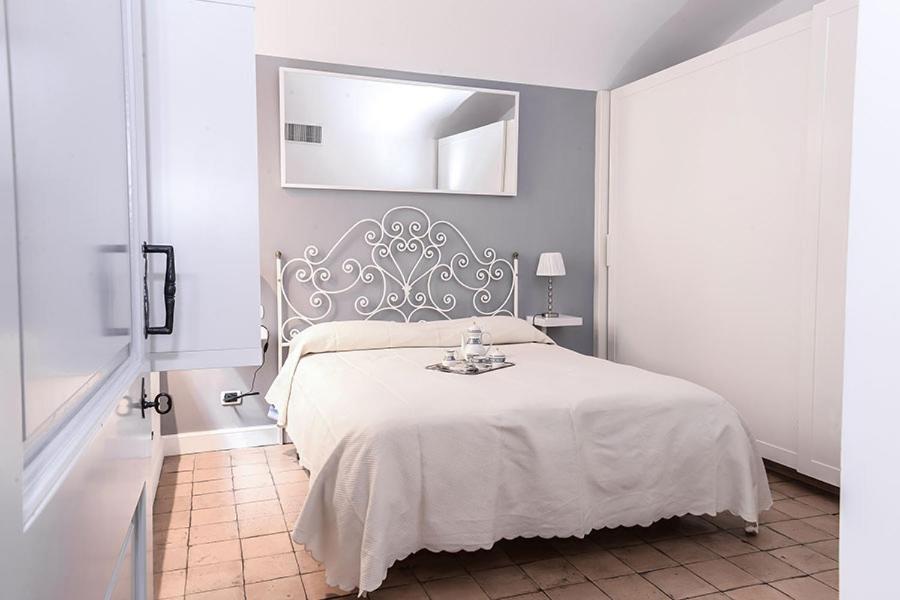 um quarto com uma cama branca e um espelho em Sweet Rome Colosseo em Roma