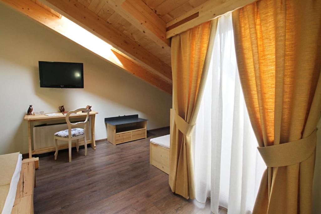 a room with a bed and a desk and a window at ALL'ALBARO AGRITURISMO in Salizzole