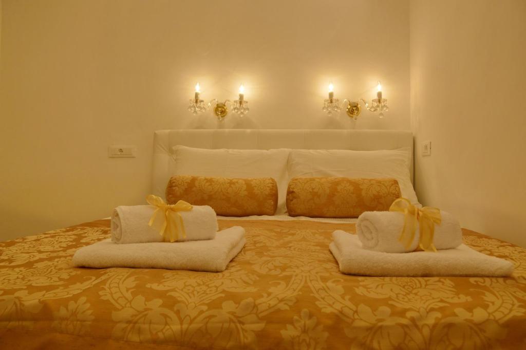 a bedroom with a large bed with two white towels at Villa Madonna della Strada A1 in Dubrovnik