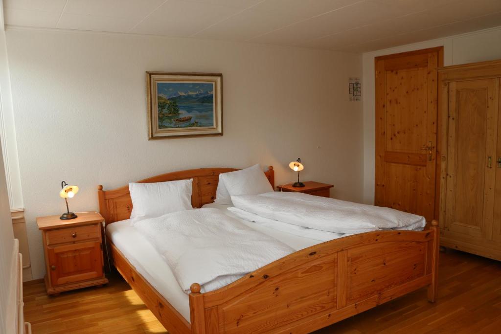 a bedroom with a wooden bed with two lamps on tables at Hotel Lowen in Walenstadt
