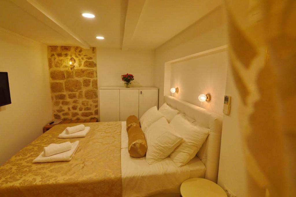 a small bedroom with a bed with white pillows at Villa Madonna della Strada A3 in Dubrovnik