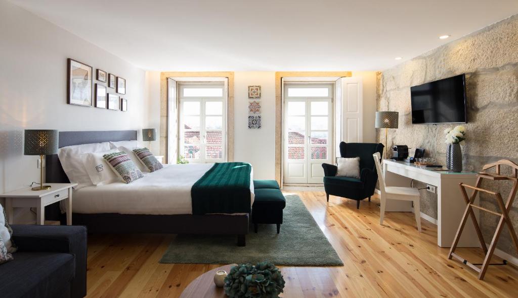 
a living room filled with furniture and a large window at Virtudes City Lofts in Porto
