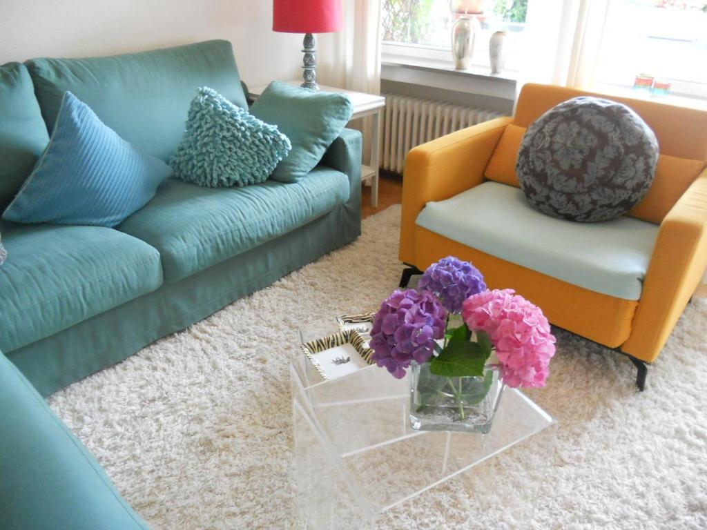 a living room with a couch and flowers on a table at Ferienwohnung in Bonn in Bonn