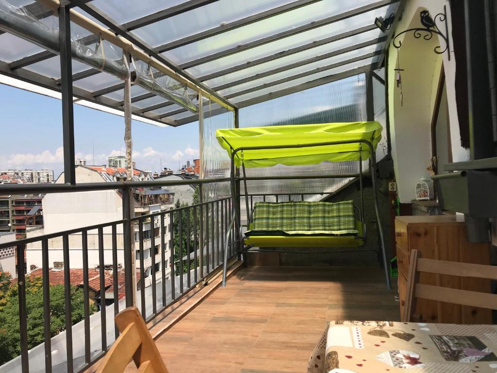 a balcony with a yellow chair and a table at Bella Vista - Cosy 1BD Flat with a Big Terrace in Sofia