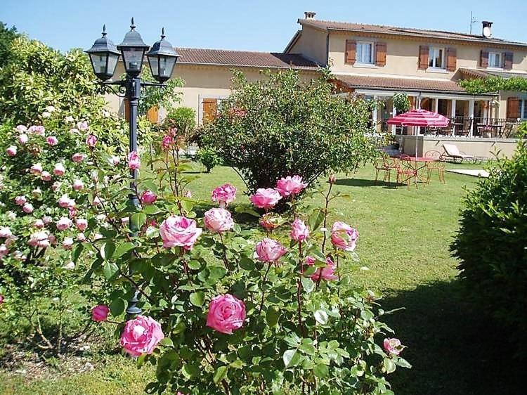 a lamp post with pink roses in a yard at La Farigoule in Berrias Et Casteljau