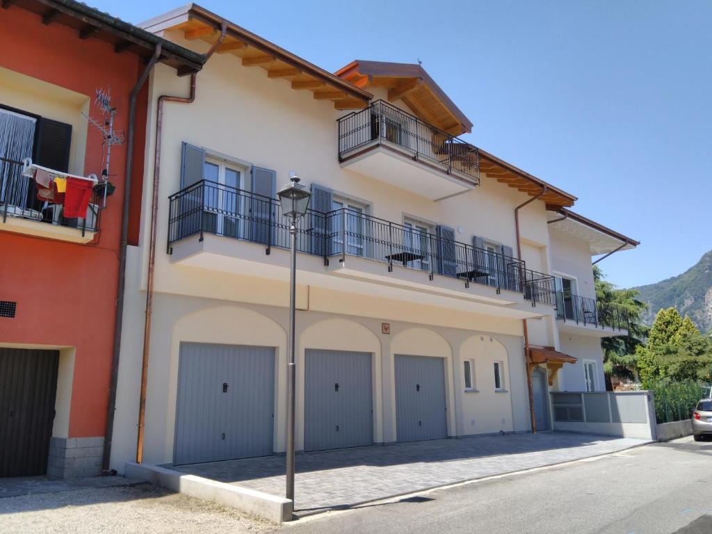 uma casa com quatro portas de garagem e duas varandas em Danilo Apartments em Baveno