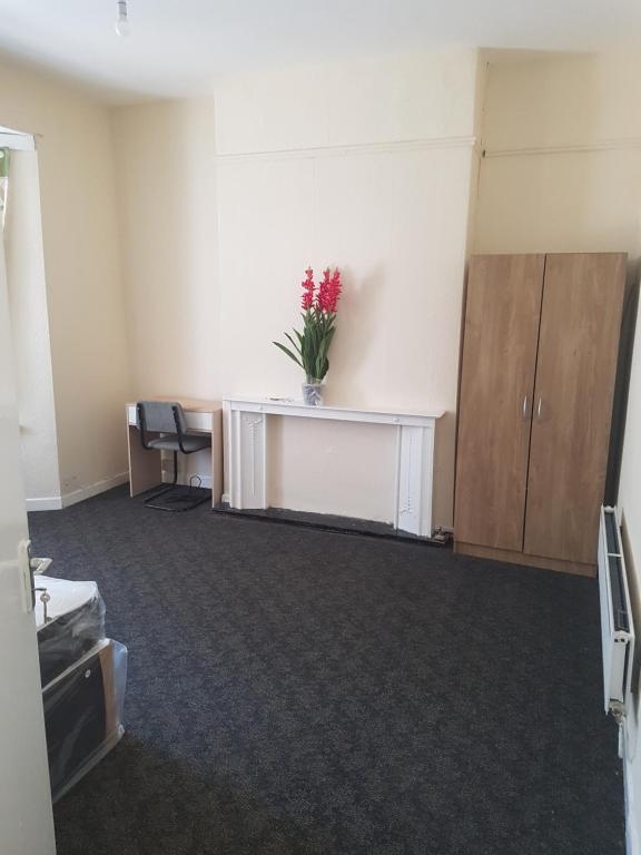 an office room with a desk with a vase of flowers on it at Richmond Road Guest House in Cardiff