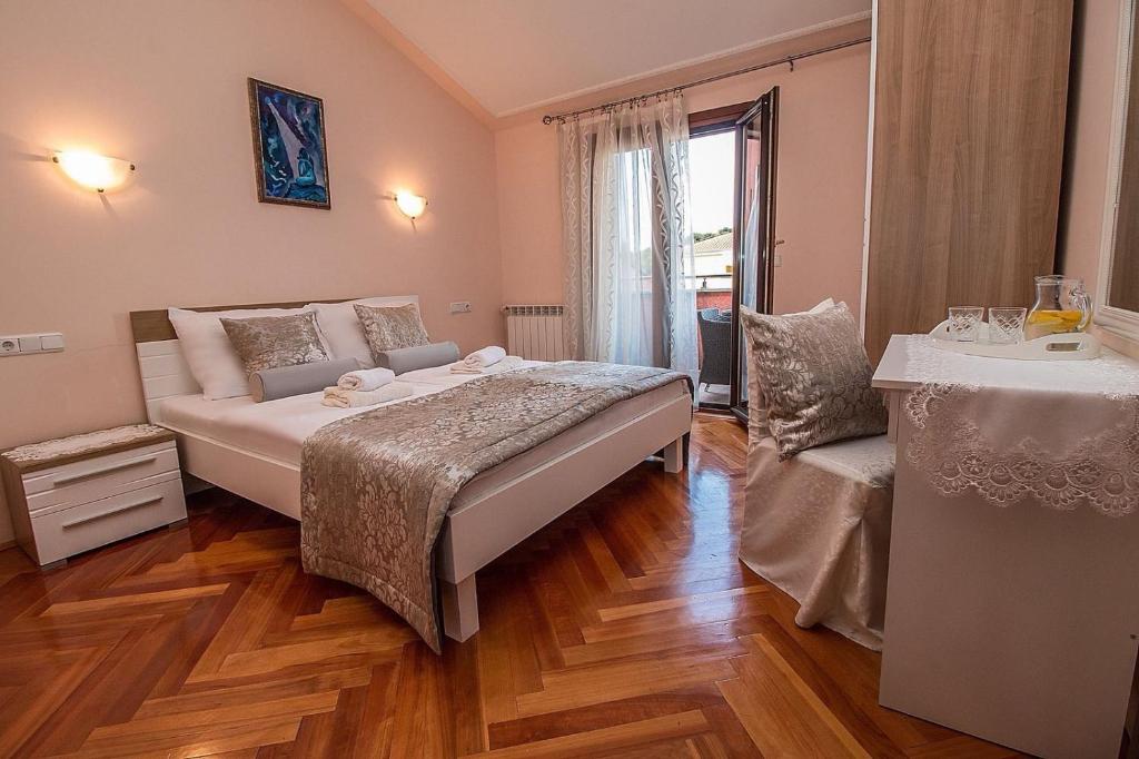 1 dormitorio con cama, mesa y ventana en Villa Rose, en Rovinj