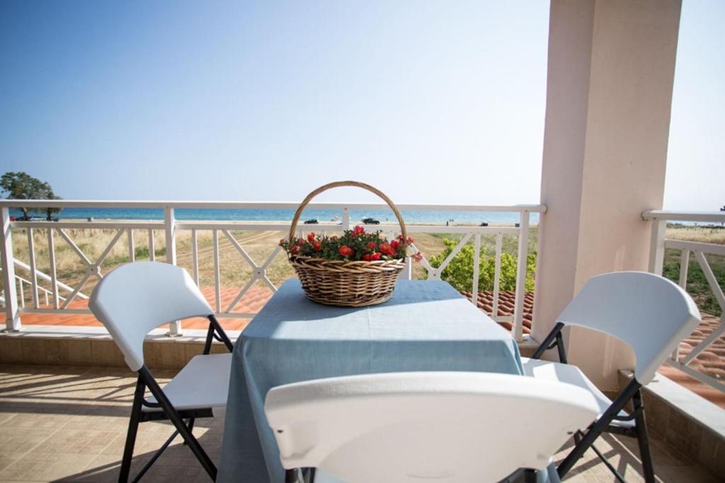 a basket of flowers sitting on a table on a balcony at "By The Sea" Family apartments in Paralia Dionysiou