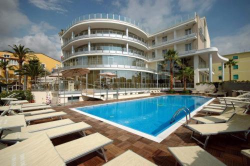 a large building with a swimming pool in front of a building at Mediterraneo Palace Hotel in Amantea