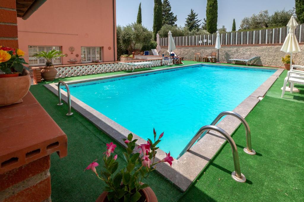 ein Pool in einem Garten mit grünem Gras in der Unterkunft Casale Gli Ulivi in Orbetello