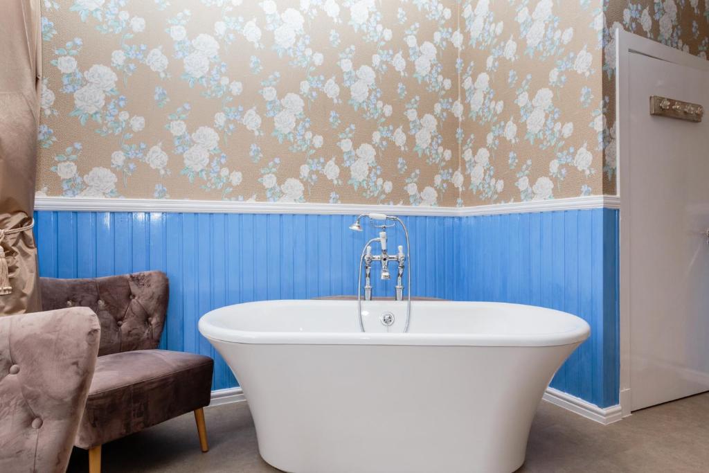 a bath tub in a bathroom with blue walls at Lunan House in Arbroath