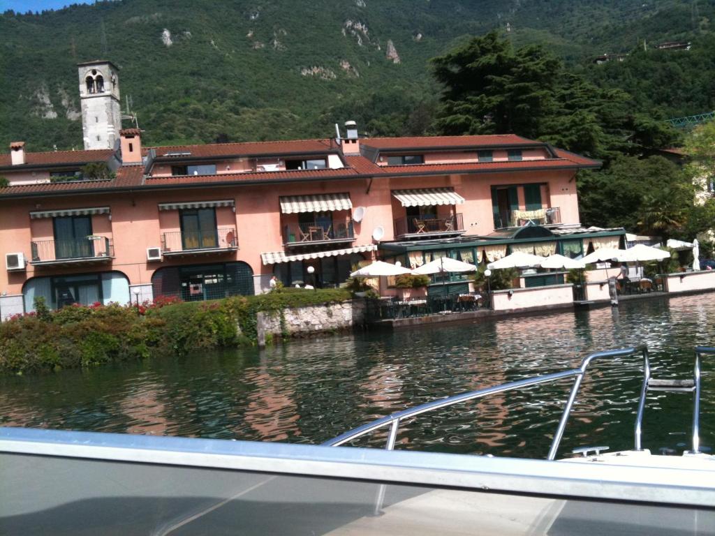 un edificio sull'acqua di fronte a una barca di Blue Lake a Lovere