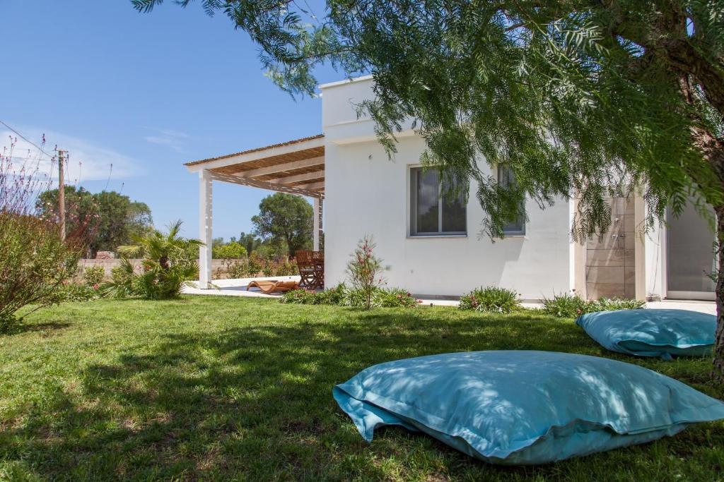 ein Haus mit zwei blauen Kissen im Hof in der Unterkunft Villa Leomaris in Torre dell'Orso