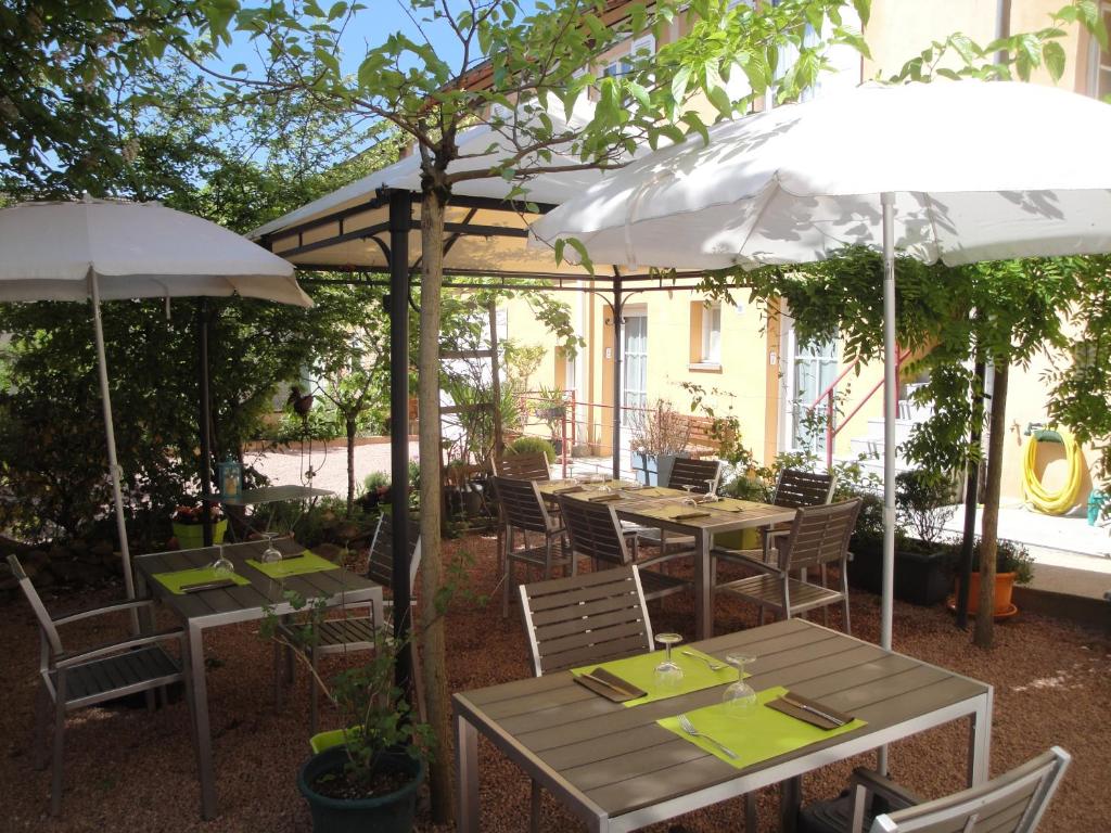 two tables and chairs with umbrellas in a garden at le Marronnier in Tramayes