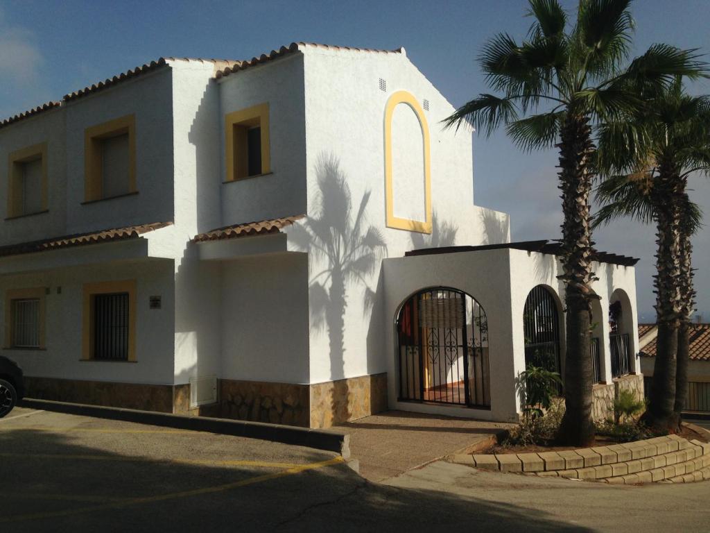 une maison blanche avec des palmiers devant elle dans l'établissement 2501 Imperial Park, à Calp