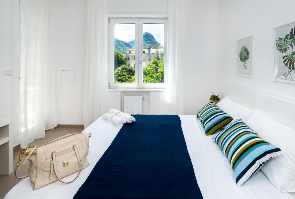 a white bedroom with a large bed with a blue blanket at Gi HOME Apartment vicino alla stazione e al Mare in Meta