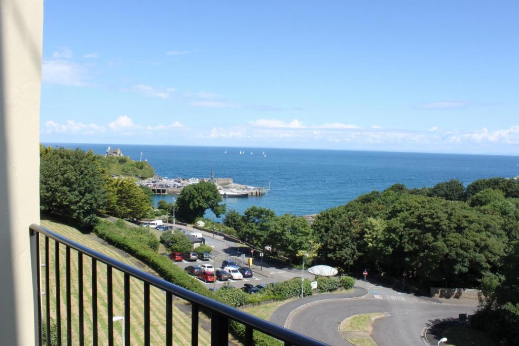 a balcony with a view of a parking lot and the ocean at The Collingdale Guest House in Ilfracombe