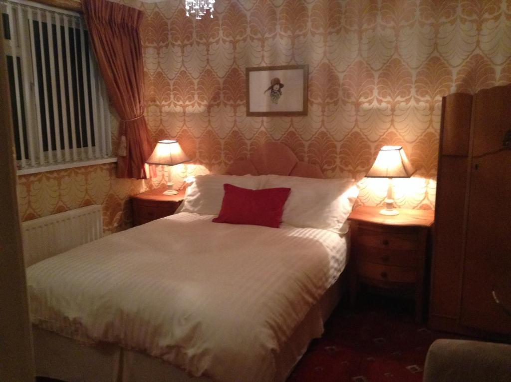 プールにあるSan Michele Guest Houseのベッドルーム1室(ベッド1台、ランプ2つ、テーブル2台付)