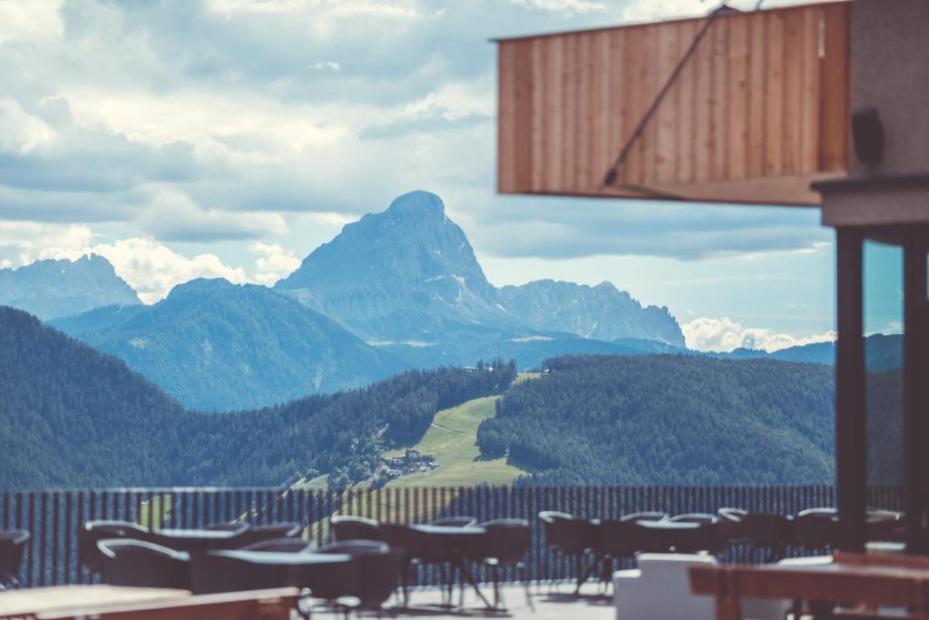 a restaurant with tables and mountains in the background at Spaces Hotel in San Vigilio Di Marebbe