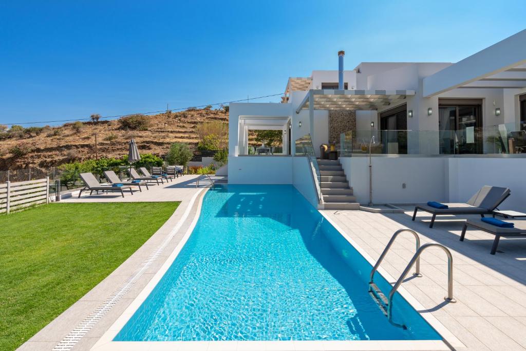 a villa with a swimming pool and a house at Eolia Iconic Villa, walking distance to the beach, By ThinkVilla in Panormos Rethymno