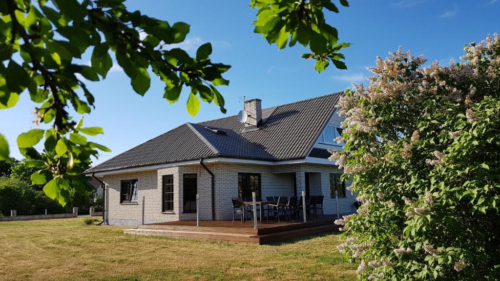 a white house with a porch and a deck at Sinilille 7 Holiday Home in Kuressaare