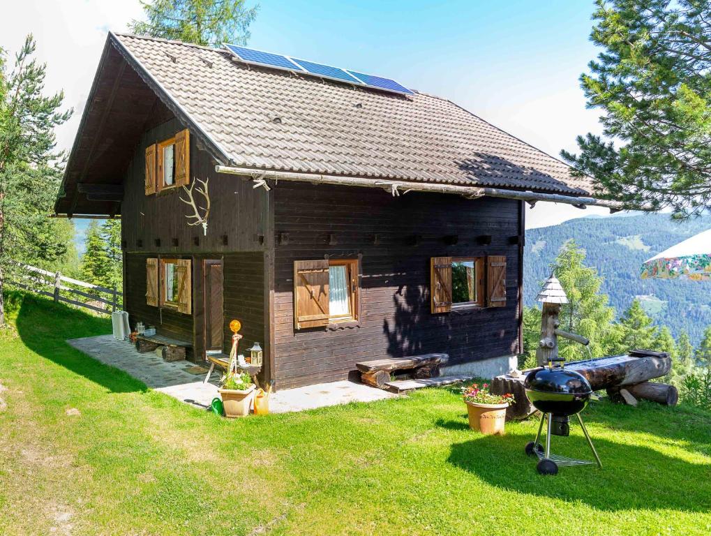 a small house with a grill in front of it at Neuwirth Hütte in Gnesau