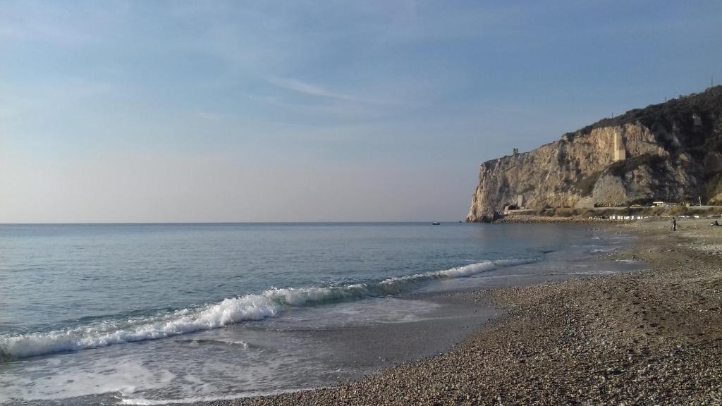 una playa con una orilla rocosa y el océano en La Rosa Dei Venti en Finale Ligure